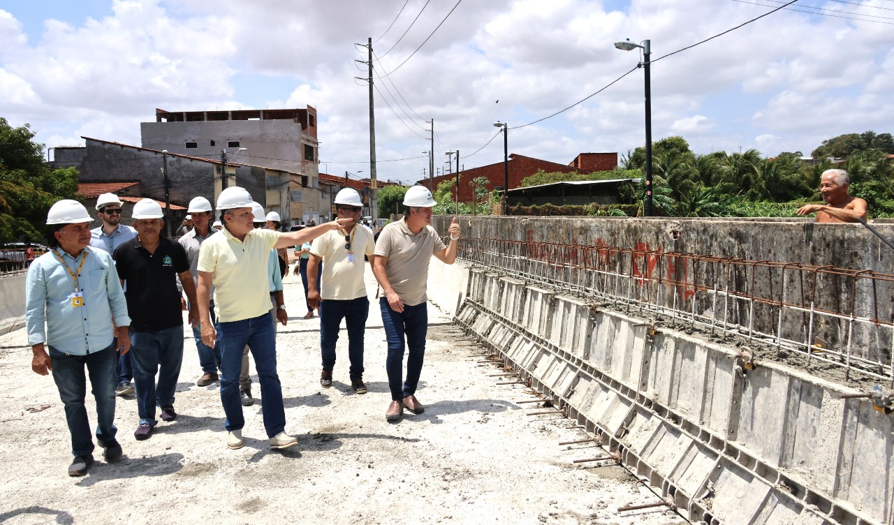 grupo de pessoas caminha na obra da ponte